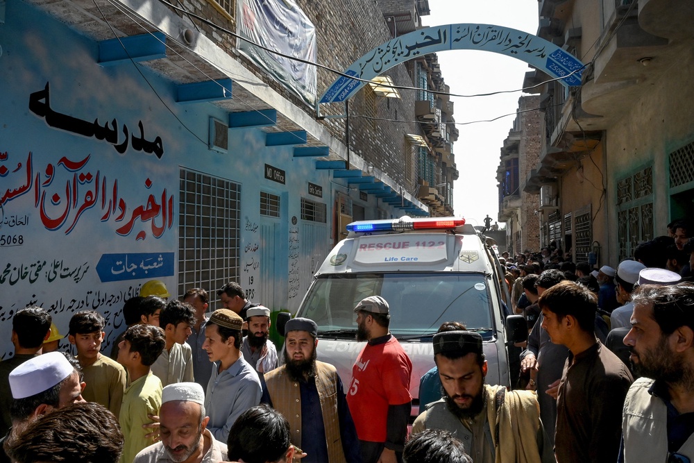 Residents gather during a search operation after a roof collapsed at a school in Peshawar (AFP/Getty)
