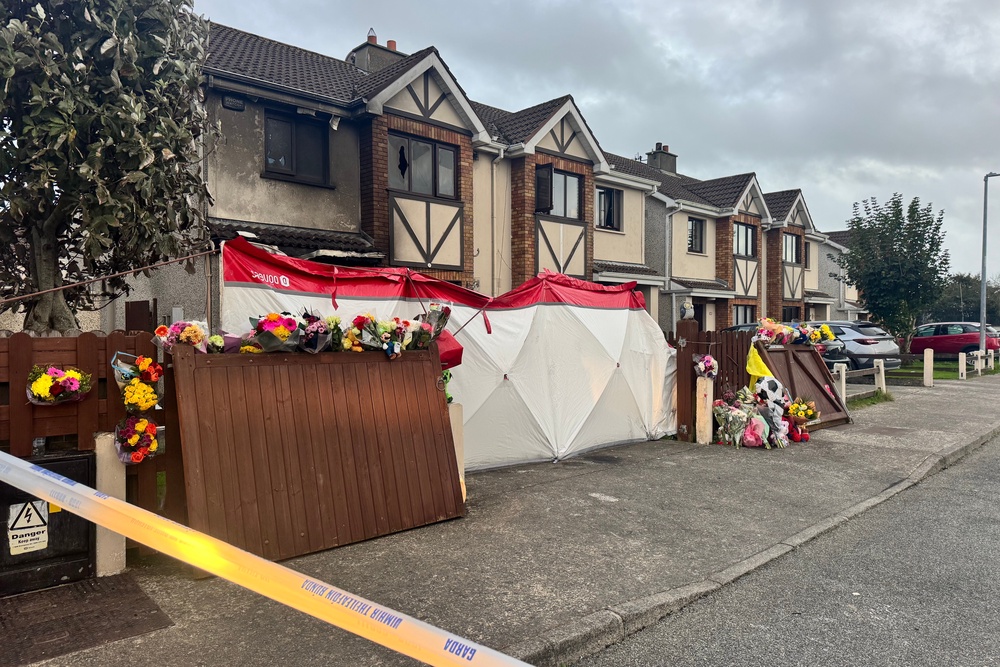Floral tributes outside the scene of suspected arson attack at a house in Birchwood, Waterford, which claimed the lives of two adults and two children. (PA)