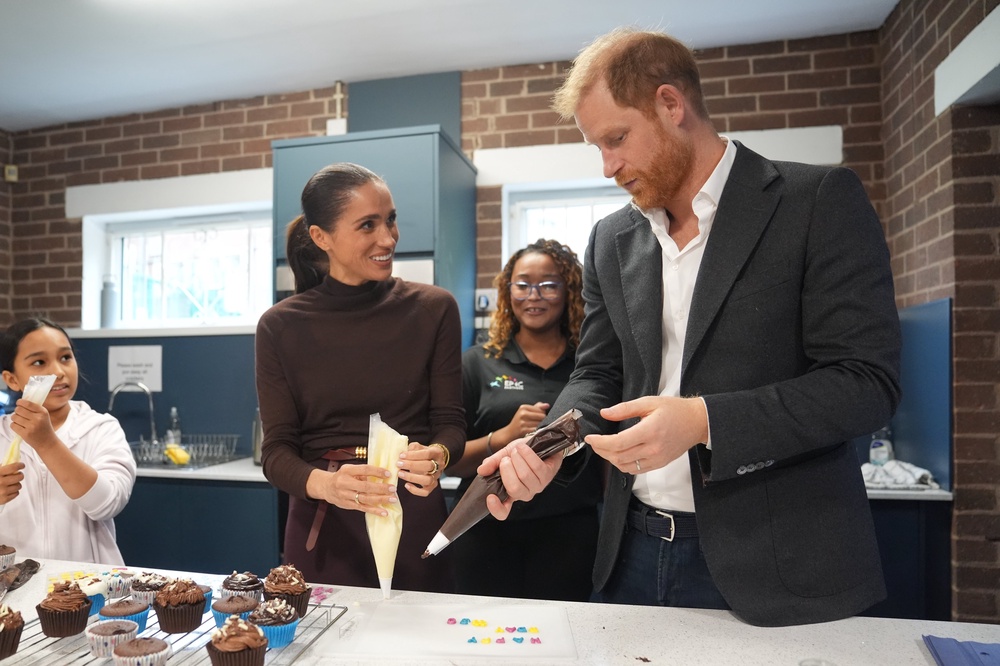 The Duke and Duchess of Sussex decorate birthday cupcakes during a visit to Epic Partners (PA)