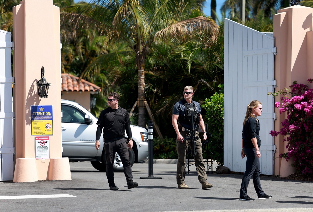 Security people along with a Secret Service agent stand at one of the entrances to former President Donald Trump's Mar-a-Lago home on March 23, 2023 (Getty)