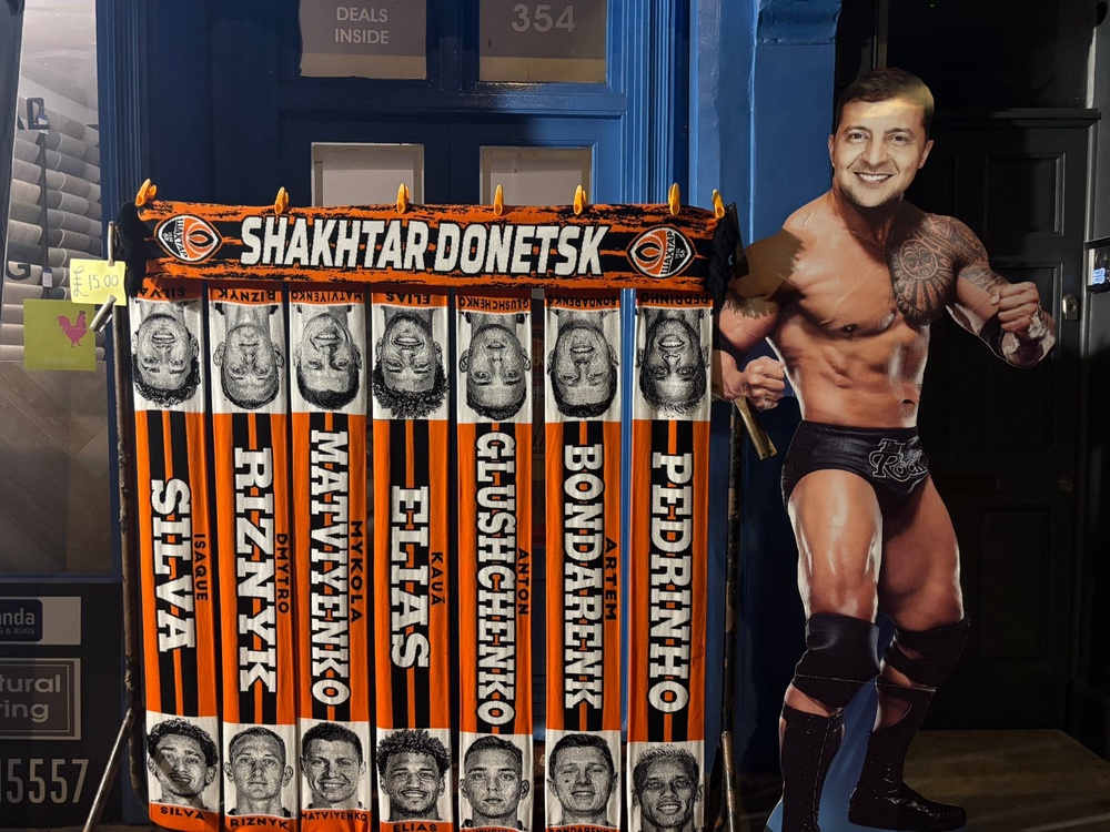 Shakhtar scarves next to a mock-up poster of President Zelenskyy as a wrestler (Kieran Jackson)