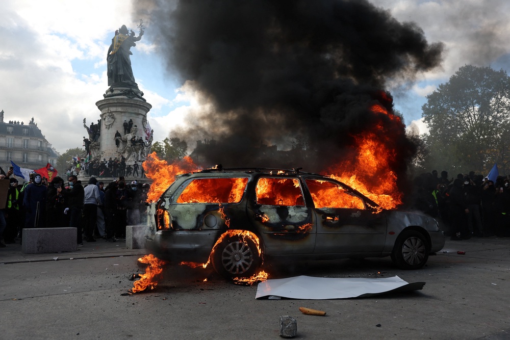 A car burns amid clashes between protesters and the French police during a demonstration (Reuters)