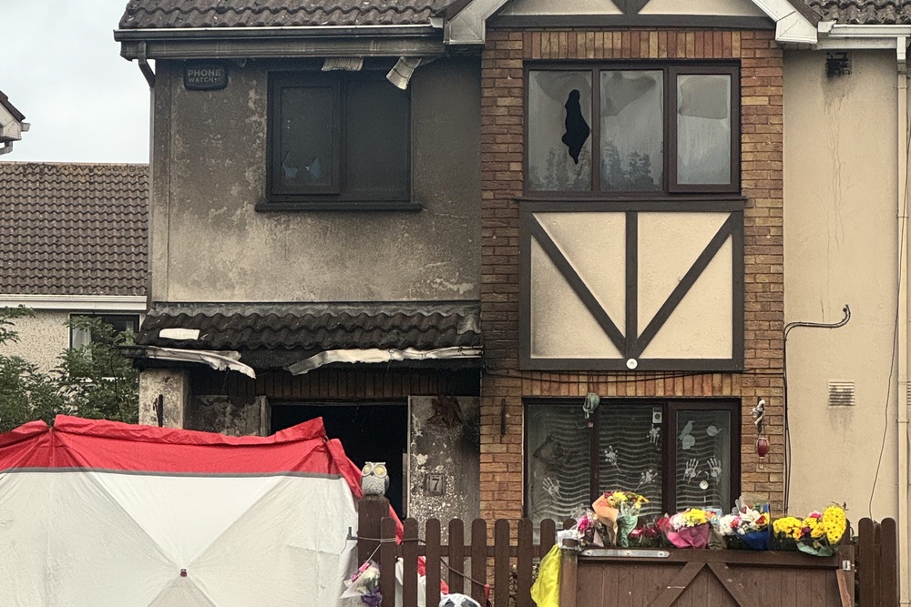 Floral tributes outside the scene of the arson attack at a house in Birchwood, Waterford (Micheal O Scannail/PA) (PA Wire)
