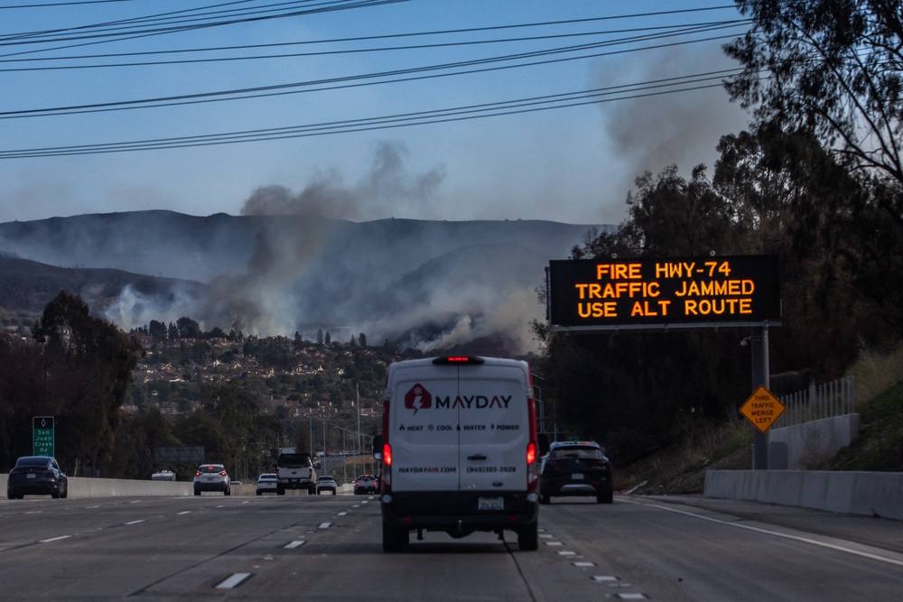 A traffic sign alerts motorists about the Norte Fire, seen in the background on the Interstate 5 freeway in San Juan Capistrano, California (AFP/Getty)