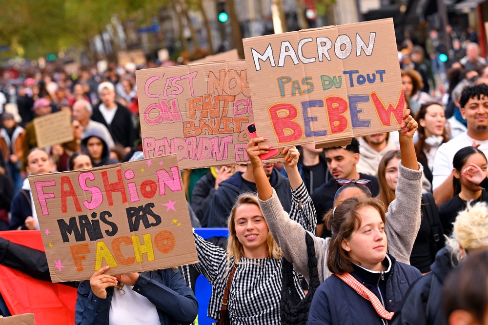 A protester marches with a placard (L) reading 
