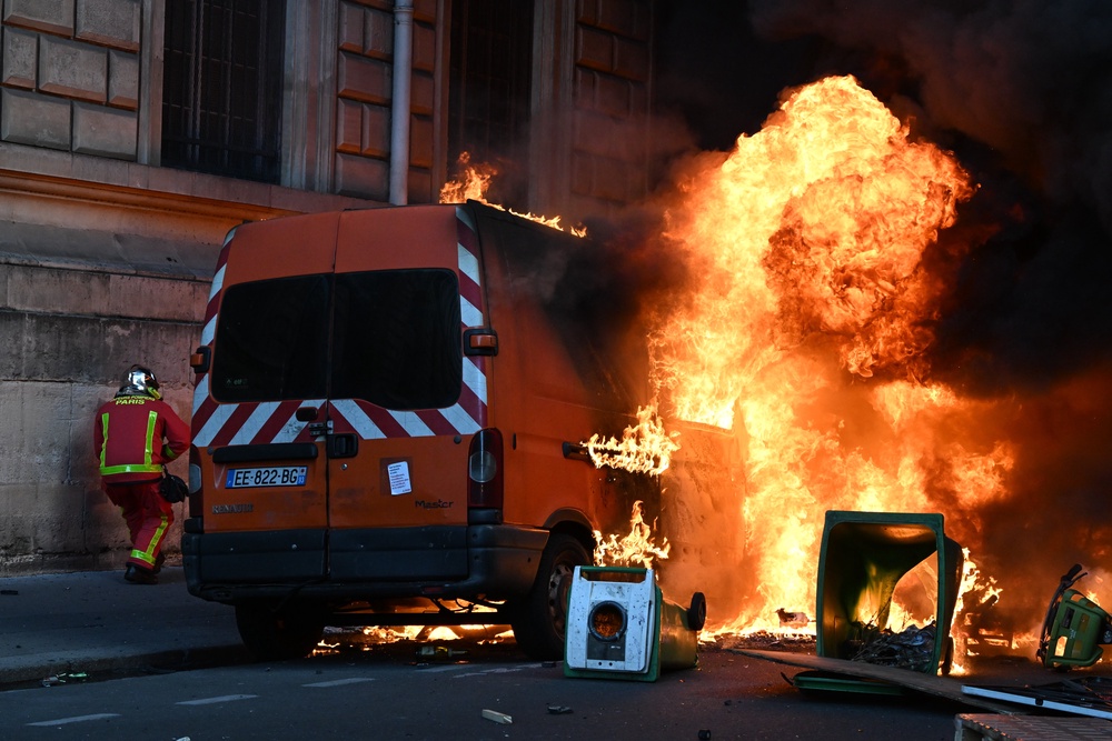 Firefighters extinguish a small truck during a demonstration against rising living costs (AP)