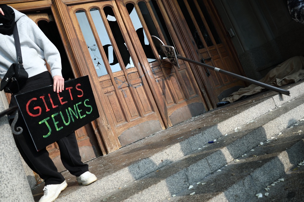 A protester holds a placard which reads as 