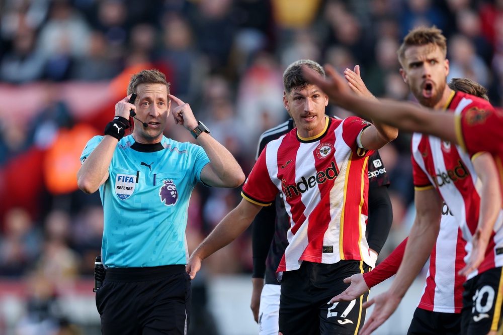 Referee John Brooks gestures to his head before showing a red card to Yehor Yarmolyuk of Brentford (Getty)