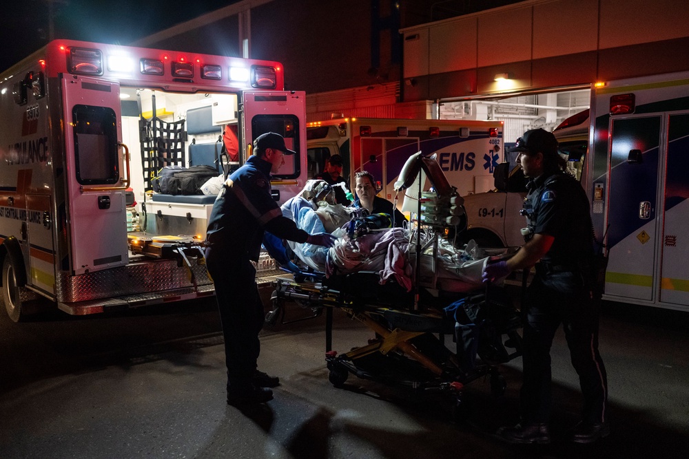 Paramedics load an injured person into an ambulance at the Wainwright Health center after a fire at Canadian Forces Base Wainwright (AP)
