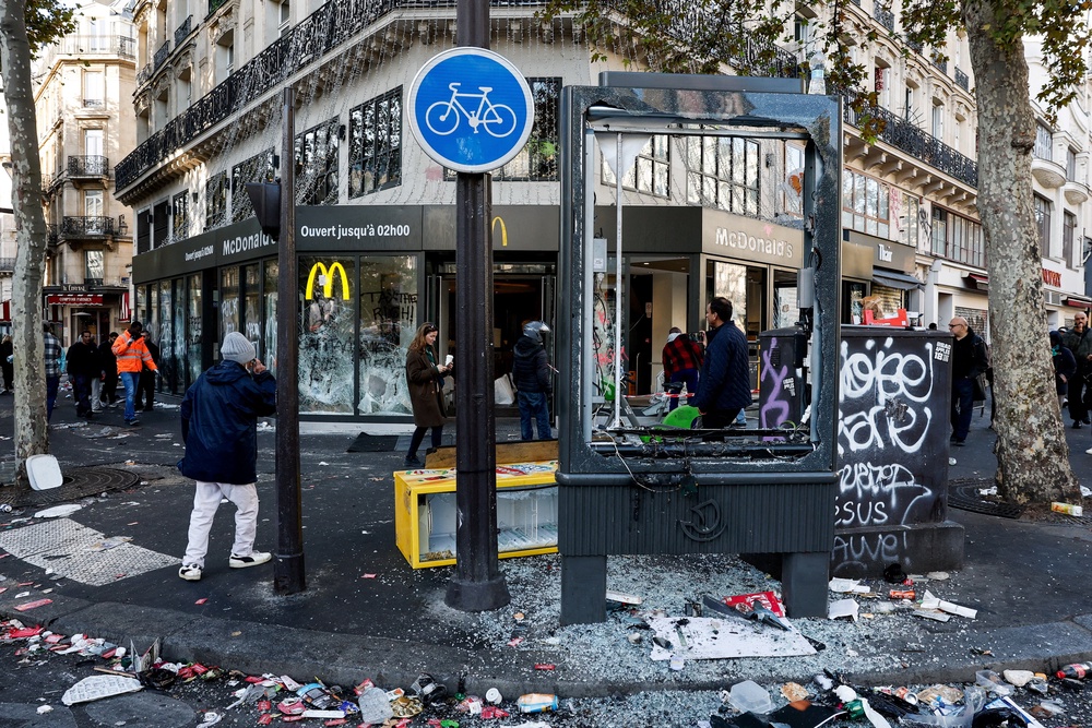 People walk past the damaged window of a McDonald's in Paris (Reuters)