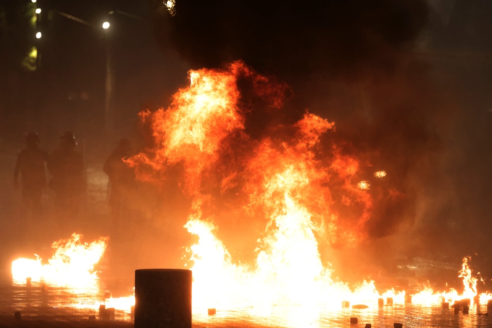 Protesters throw petrol bombs at police during clashes at an anti-government demonstration in Tirana (AP)