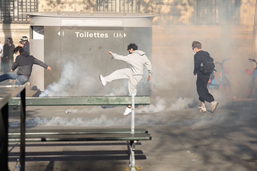 A protester kicks away a tear gas projectile at Place de la Republique during another day of tensions following the national demonstration (AFP/Getty)