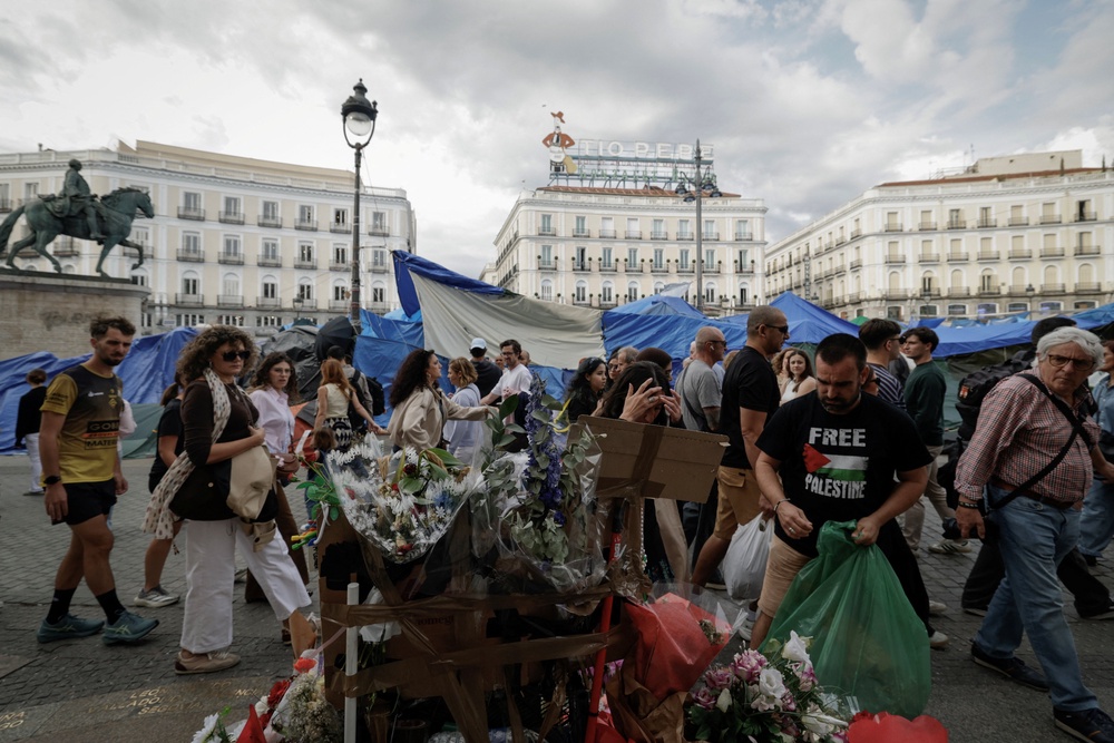 People walk past a makeshift memorial outside the Community of Madrid government building for the late Maricarmen, on Saturday (Reuters)