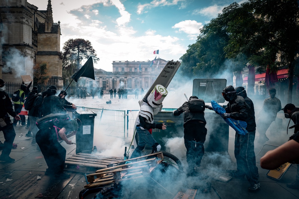 Masked demonstrators move around overturned debris amid thick smoke on Place Pey Berland, in front of Bordeaux City Hall, on Saturday (AFP/Getty)