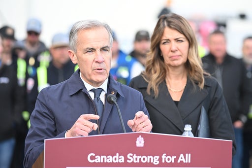 Prime Minister Mark Carney speaks as Alberta Premier Danielle Smith listens during a news conference in Fort McMurray, Alberta (AP)
