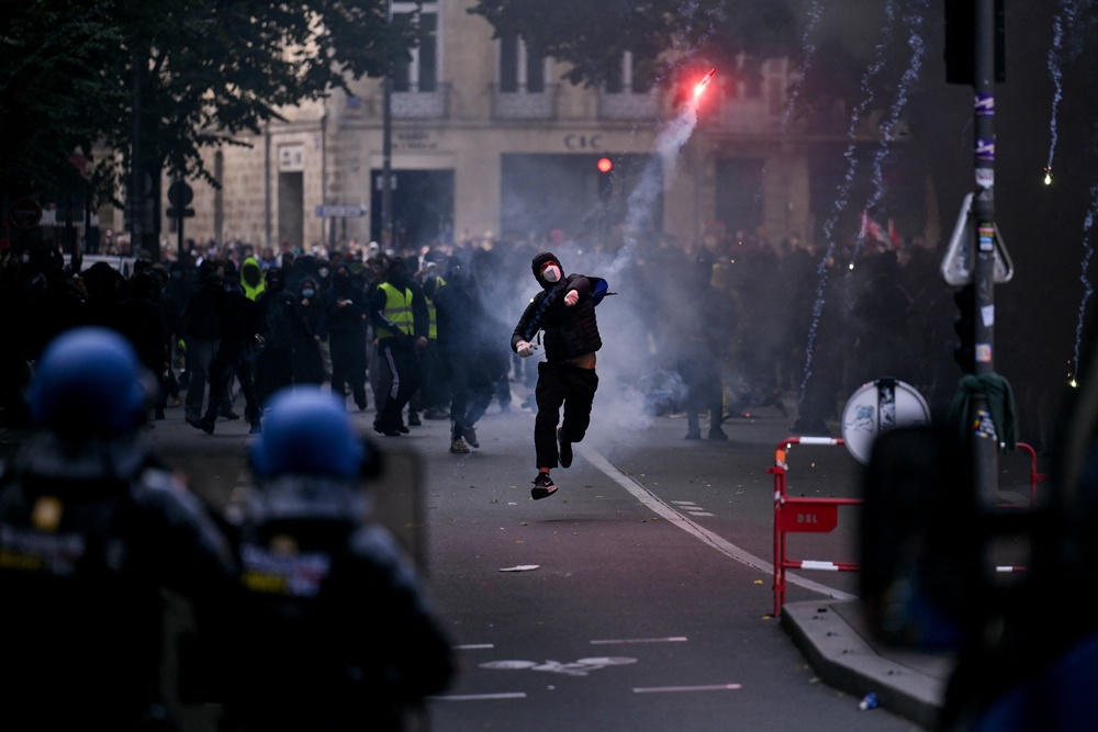 A protester throws a smoke flare towards French gendarmes during a demonstration in Bordeaux on Saturday (AFP/Getty)