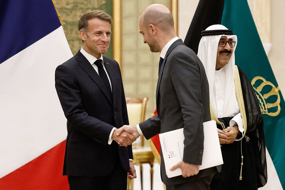Emmanuel Macron (L) shakes hands with French foreign minister Jean-Noel Barrott at Bayan Palace in Kuwait City on October 19 (AFP/Getty)