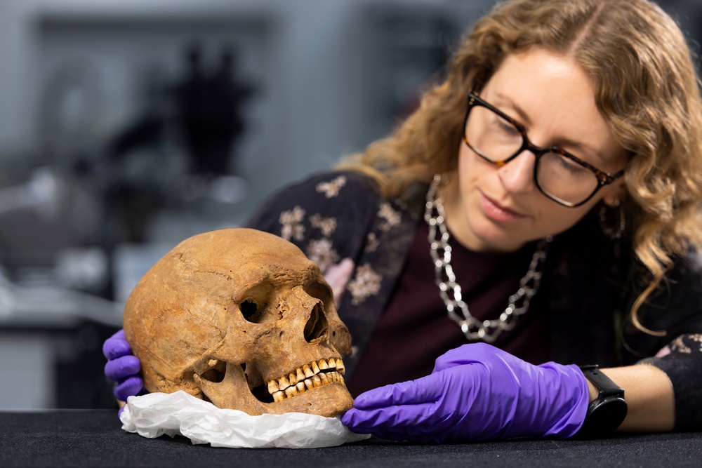 Dr Jess Thompson examining the skull of a man from Roman Scotland (PA)