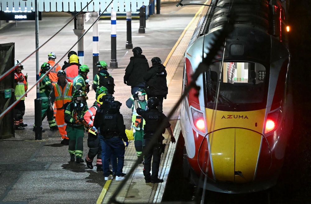 Police officers and members of the Emergency services work alongside an LNER Azuma train at Huntingdon Station in Huntingdon (AFP/Getty)