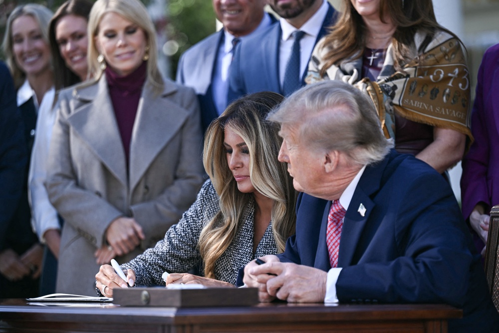 Donald and Melania Trump signed the executive order together as he mused:  'I don't know if her signature means anything' (AFP via Getty Images)
