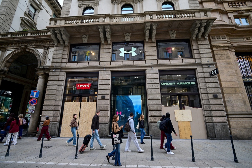 Pedestrians walk past boarded-up Levi's and Under Armour storefronts (REUTERS)