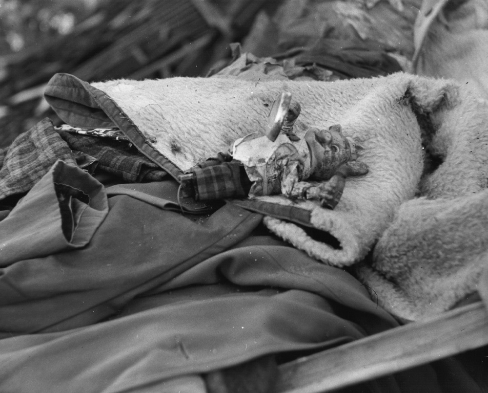 A child's toy on a heap of clothing that has been pulled from the rubble by rescue workers (Getty)
