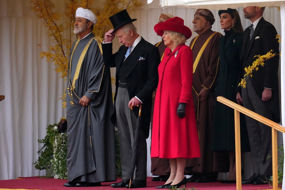 The Sultan, Charles and Camilla watch the guard of honour marching past (Reuters)