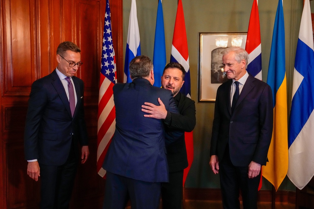 Ukrainian President Volodymyr Zelensky, centre, hugs US envoy Steve Witkoff despite growing tensions between Kyiv and Washington (AP)