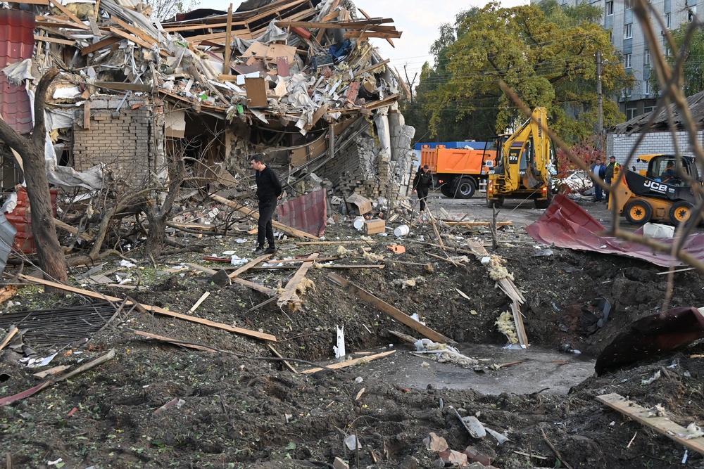 A man walks past a destroyed building next to a crater following an air attack in Kharkiv (AFP/Getty)