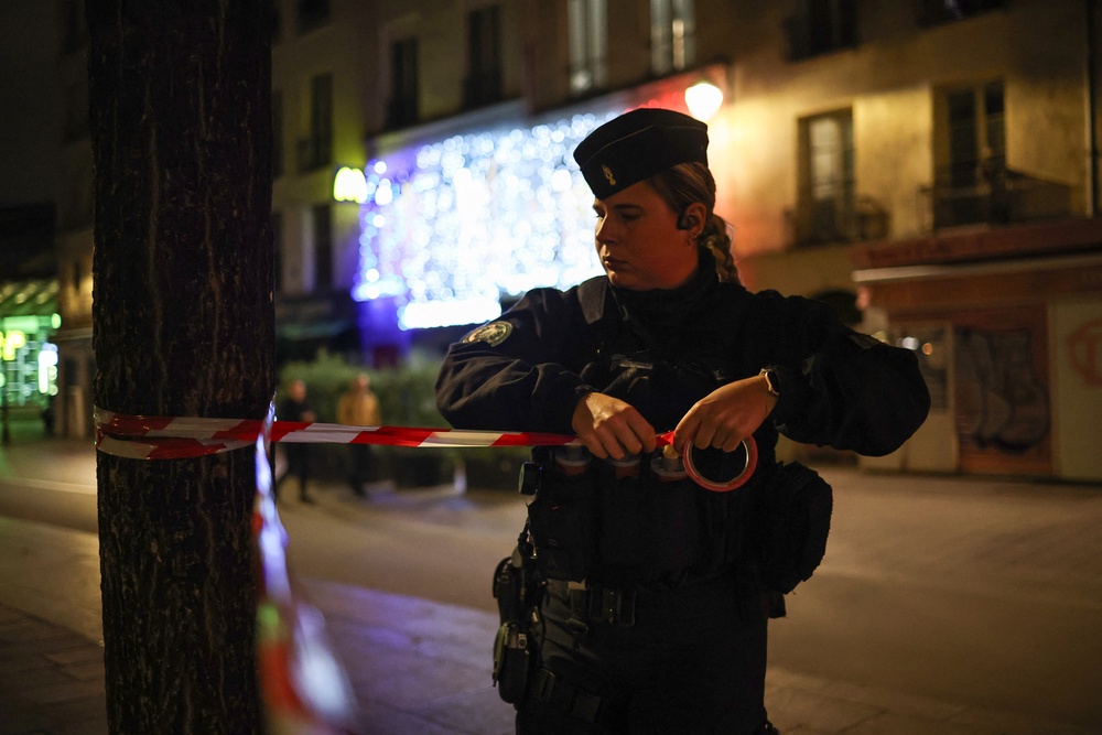 A police officer puts in place a perimeter tape near Chatelet - Les Halles to enforce a curfew, in Paris on 20 October (AFP/Getty)