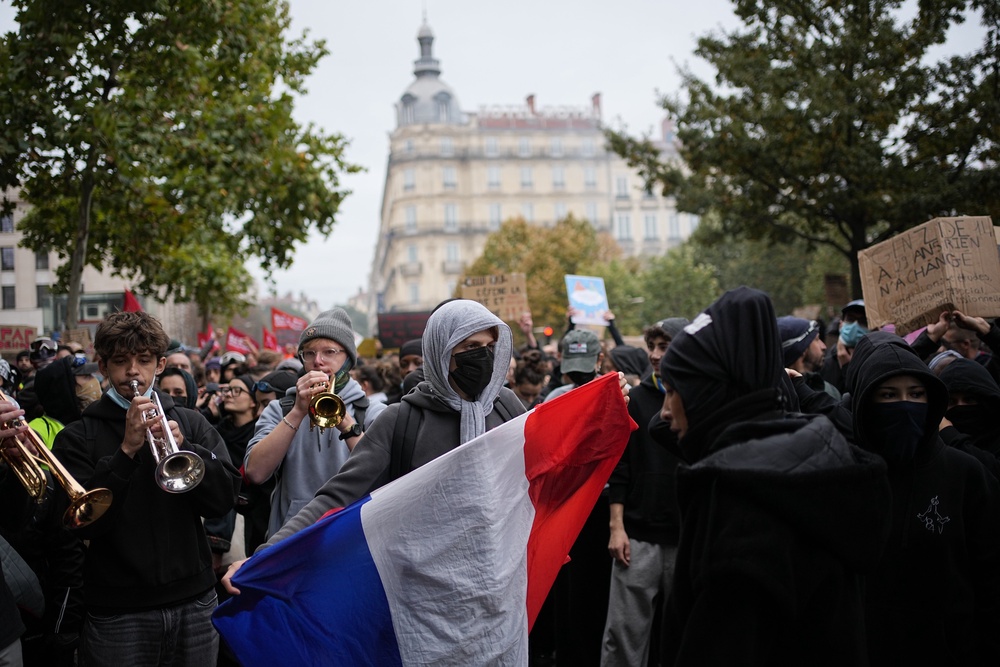 A protesters holds a French flag during a demonstration against rising living costs, joining students' grievances, in Lyon, France, Saturday, Oct. 17, 2026 (AP Photo/Laurent Cipriani)