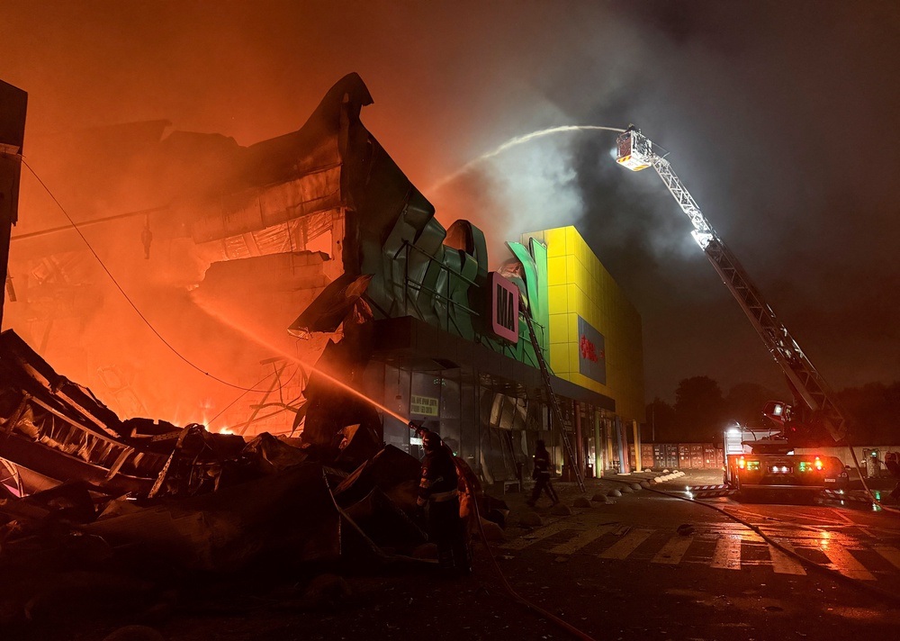 Firefighters work at the site of a shopping centre hit by a Russian missile attack on Thursday (Reuters)