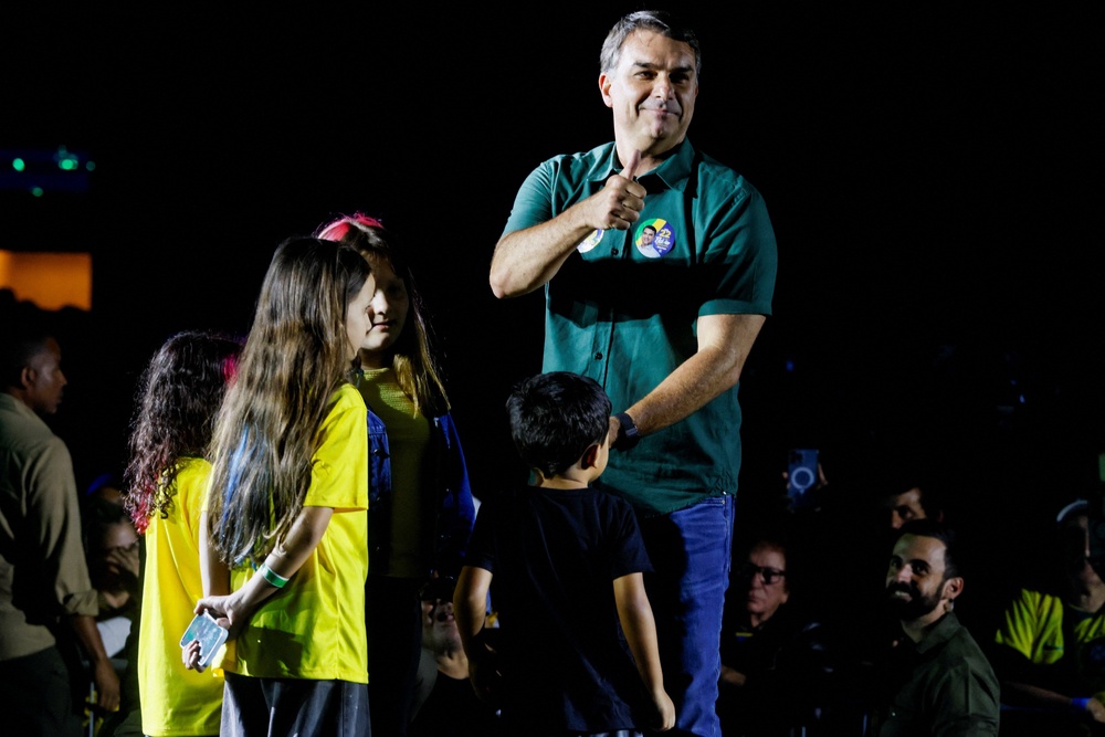 Presidential candidate Flavio Bolsonaro from the Liberal Party is joined on stage in Guarulhos, Brazil by children from the audience (Reuters)