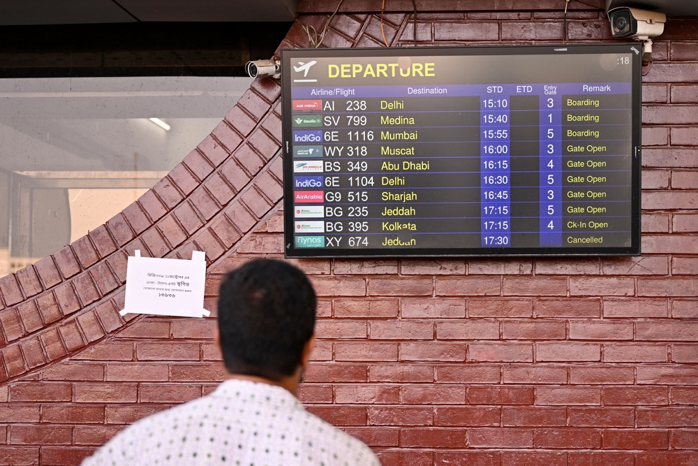 A man looks at a screen displaying the flight schedule at the Hazrat Shahjalal International Airport in Dhaka on 12 October 2026 as Saudi Arabia-bound flights remain cancelled a day after a Houthi strike at Riyadh's international airport (AFP/Getty)