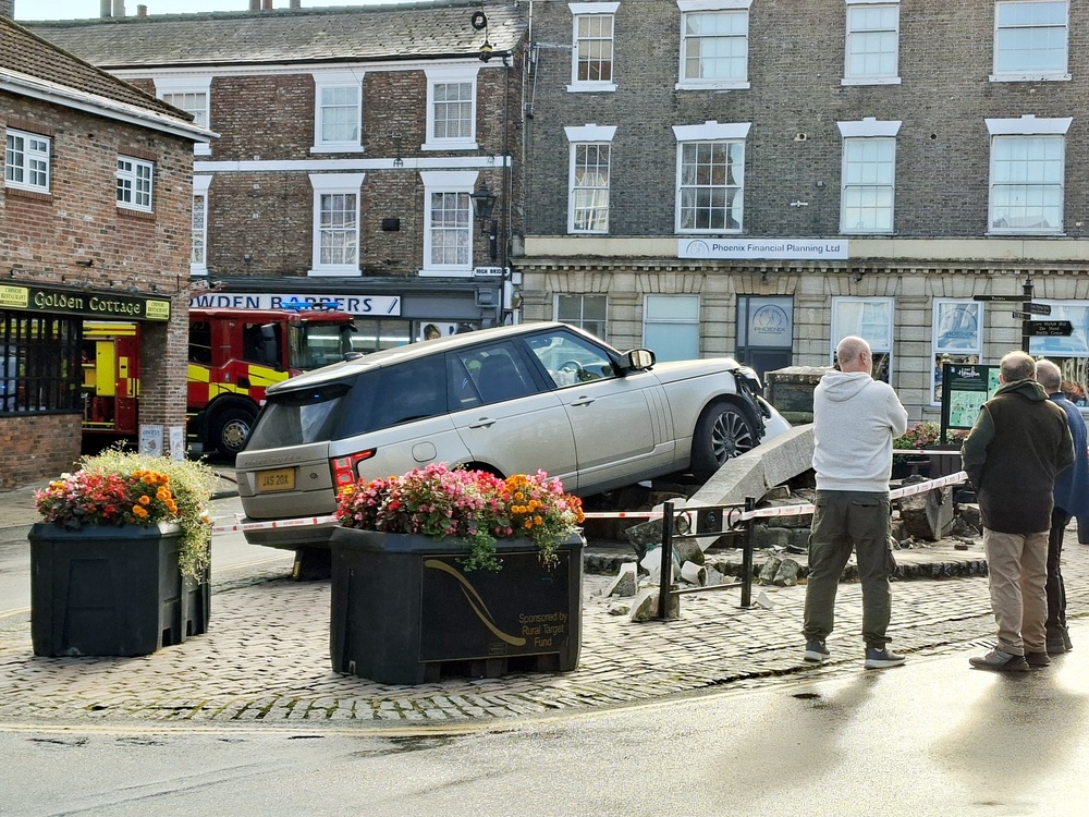 Locals examine the scene after a Range Rover mounted a paved area and knocked down the Market Cross in Howden (Amy Crowther/PA) (PA Wire)
