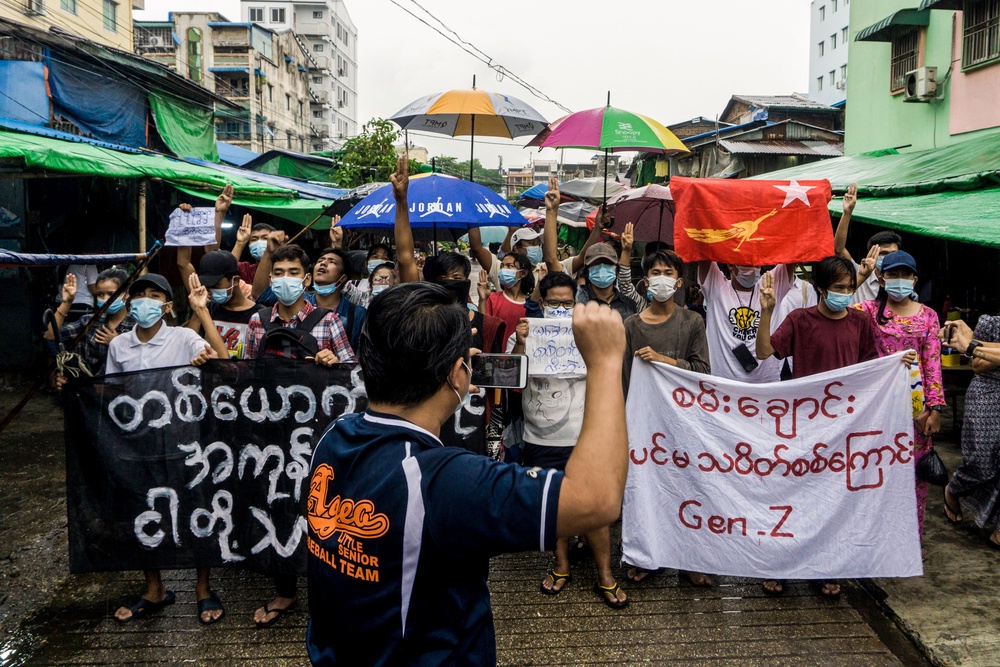 A man records protesters on his mobile phone as they take part in a demonstration against the military coup in Yangon on May 21, 2021 (AFP/Getty)