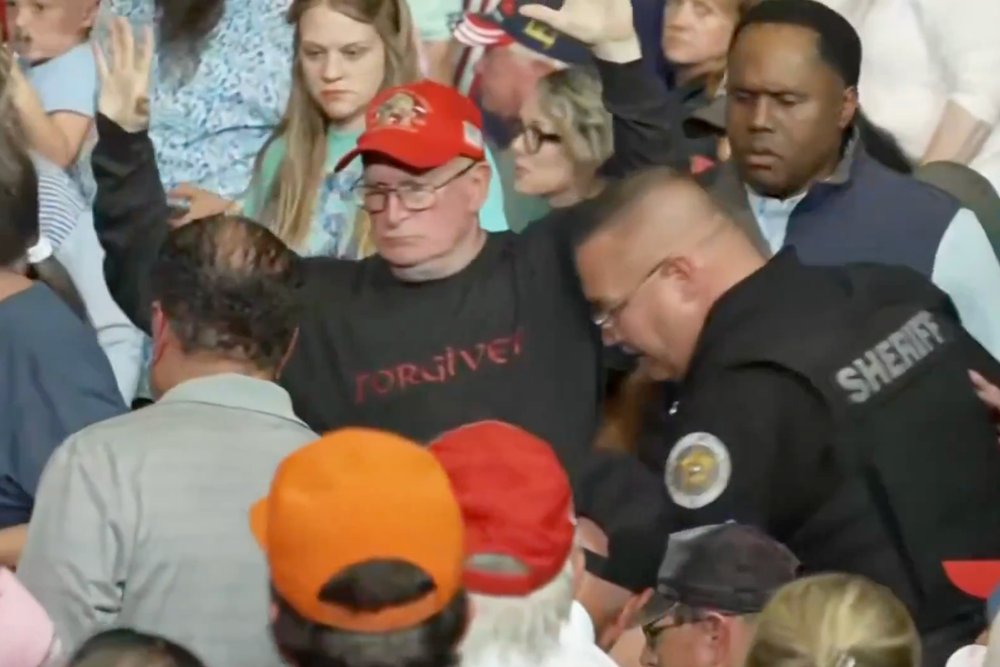 Police came to the aid of the protester struck during the melee and led him out of the venue for his own safety as Trump providing a gloating commentary from the stage (Acyn/X)