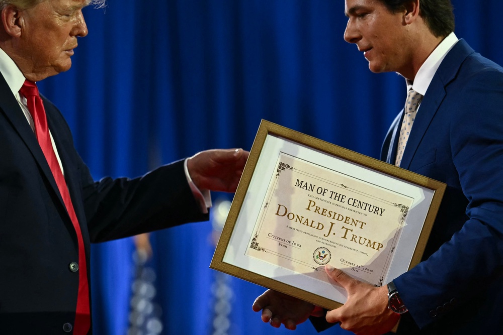 Trump receives his framed certificate from Mitchell (AFP/Getty)