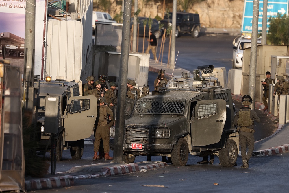 Israeli forces deploy at the scene following an exchange of fire with two Palestinian men at a northern checkpoint in Hebron, in the Israeli-occupied West Bank (AFP/Getty)