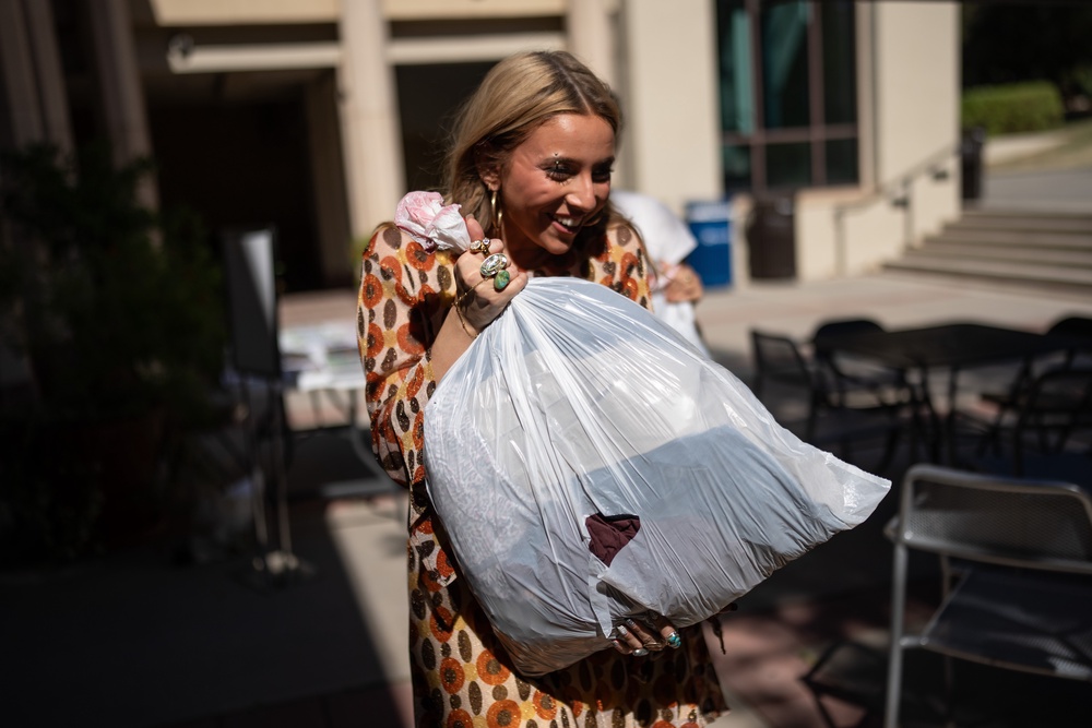 Sustainable fashion advocate Lexy Silverstein smiles while carrying a bag of costumes dropped off for a Halloween costume swap (AP)