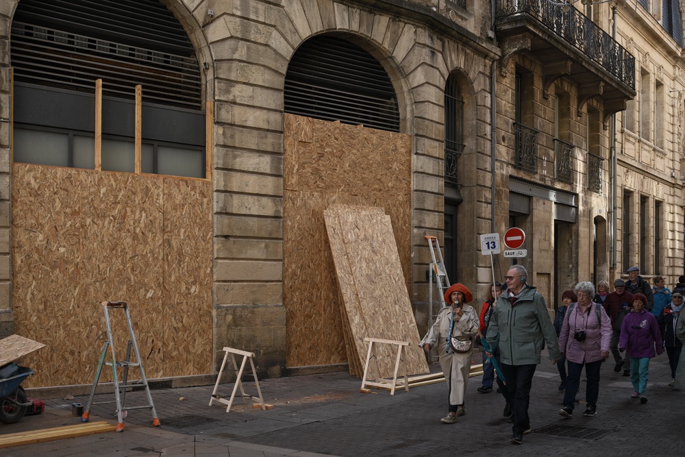 A guided tour group walks past boarded-up shops ahead of a demonstration planned (AFP/Getty)
