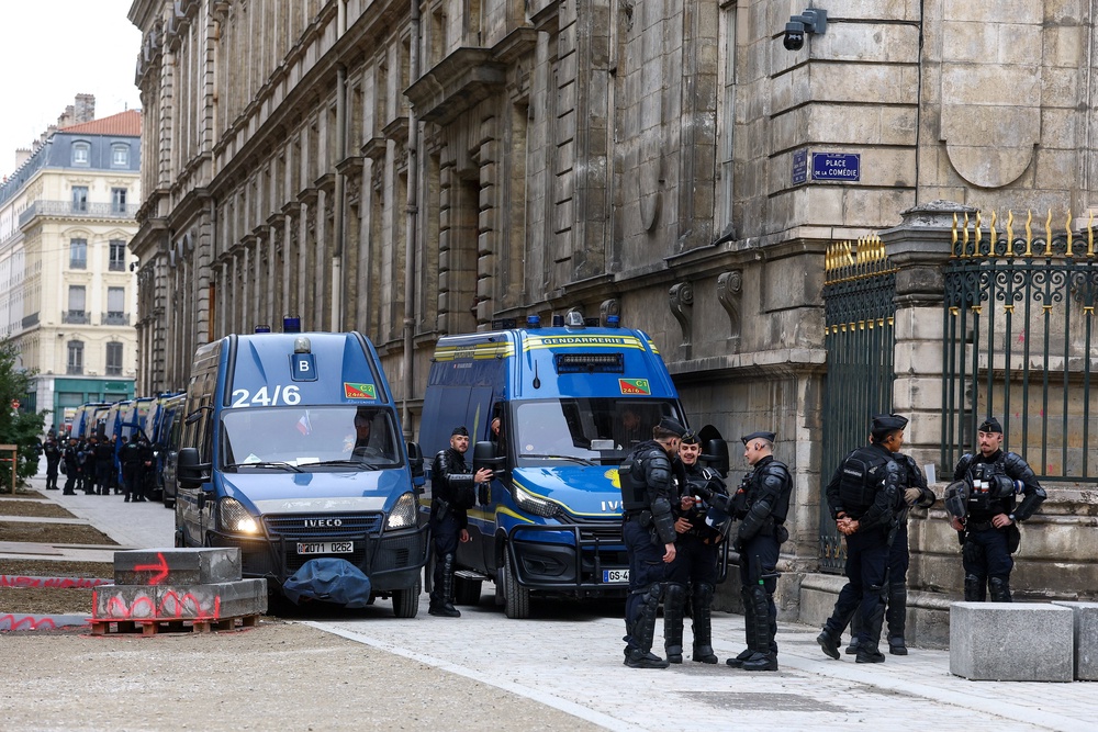 Police officers stand next to a line of police vehicles near a city hall (Reuters)