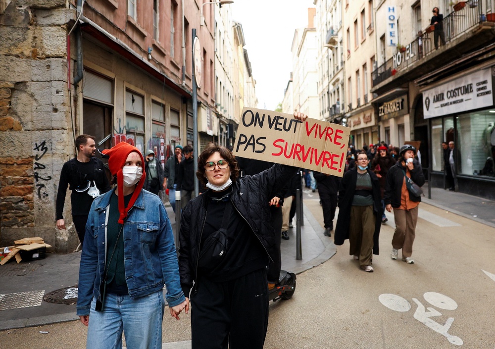 A demonstrator holds up a placard reading 