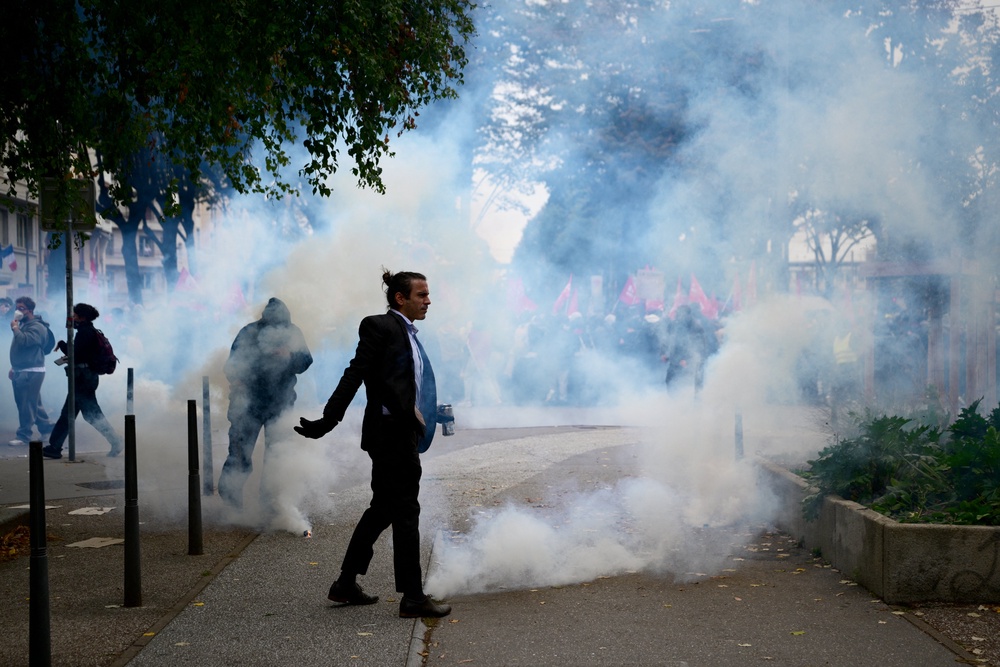 A demonstrator stands next to fuming tear gas pellets amid a cloud a of tear gas in Lyon (AFP/Getty)