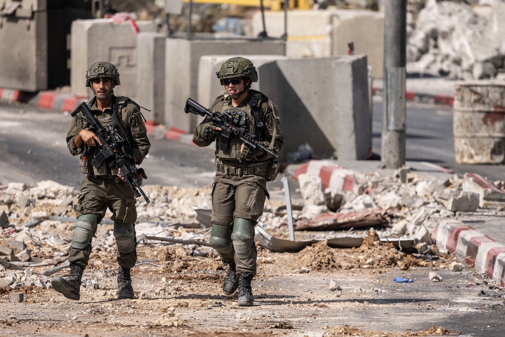 Israeli soldiers patrol at the northern checkpoint in Hebron, in the occupied West Bank, on Saturday 24 October (AFP/Getty)