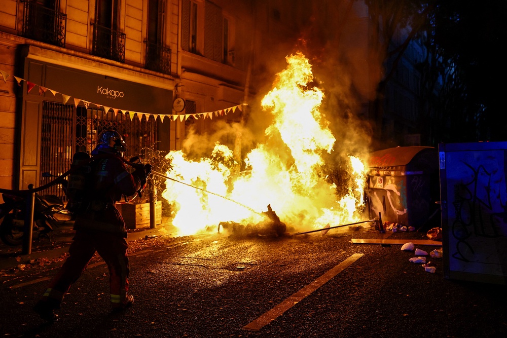 A french Pompier fireman extinguishes a burning barricade (AFP via Getty Images)