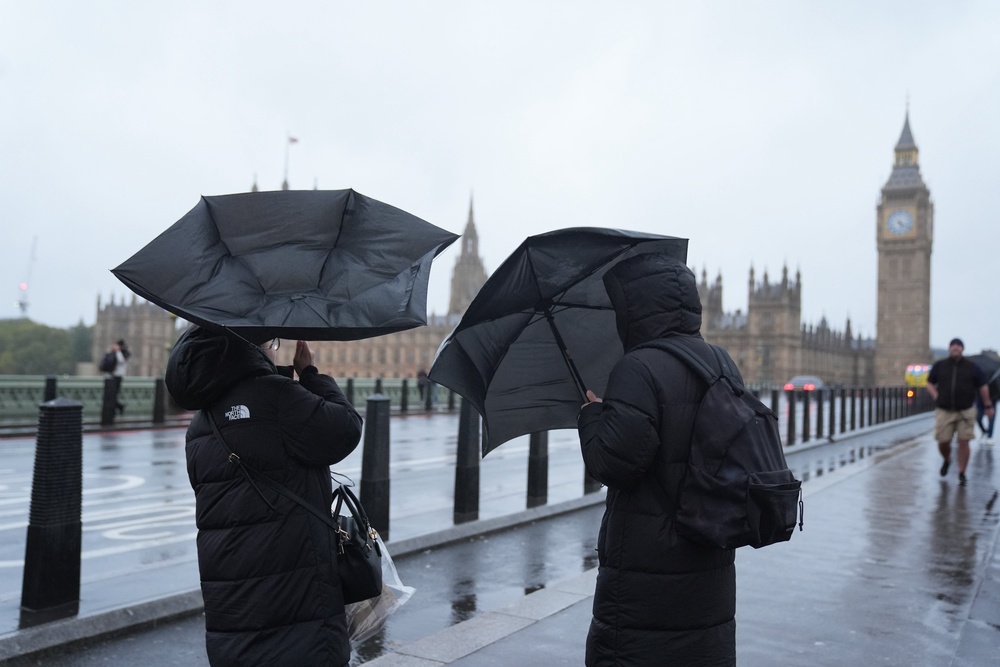 People in the rain on Westminster Bridge, London. An amber weather warning is in place across Scotland, the north of England down to Carlisle and the north-east of Northern Ireland on Saturday (PA)