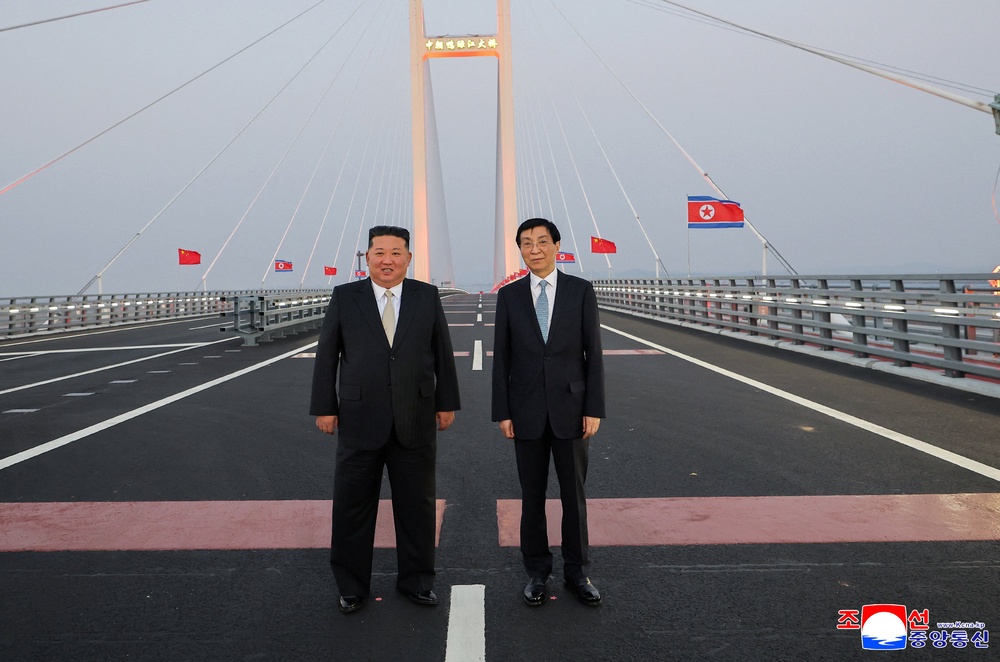 North Korean leader Kim Jong Un and Chinese People's Political Consultative Conference (CPPCC) Chairman Wang Huning pose for a photograph on the New Yalu River Bridge linking Dandong, China, and Sinuiju, North Korea (Reuters)