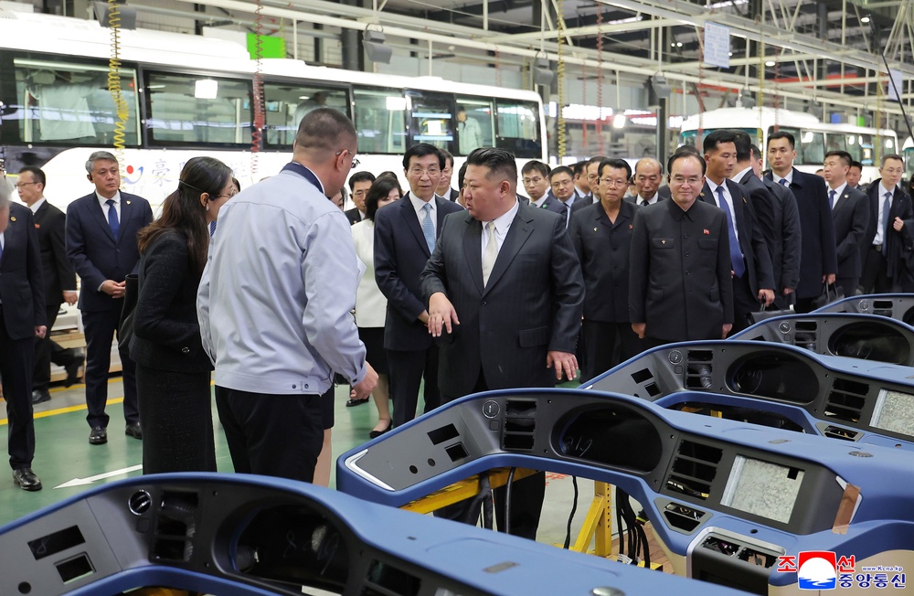 In this photo provided by the North Korean government, its leader Kim Jong Un, front right, tours a bus factory in Dandong, China Saturday, Oct. 24, 2026 (AP)