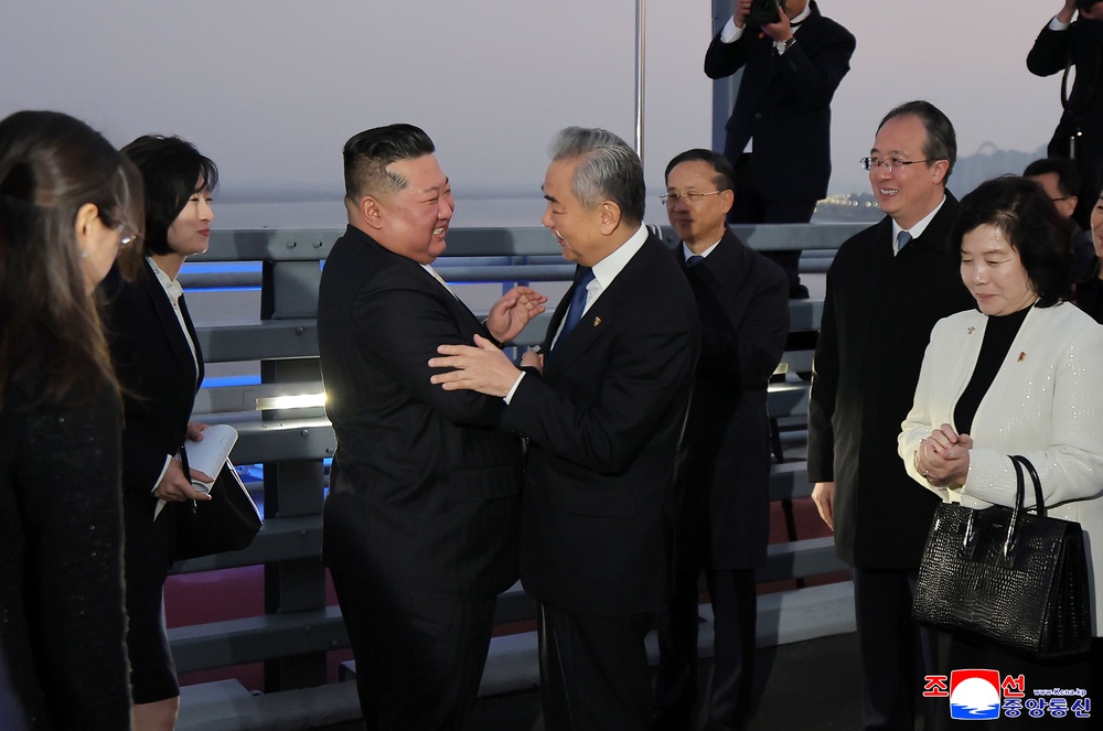 Kim Jong Un, center left, bids farewell to Chinese Foreign Minister Wang Yi on the New Yalu River Bridge, that connects the two countries, after his visit to Dandong, China (AP)